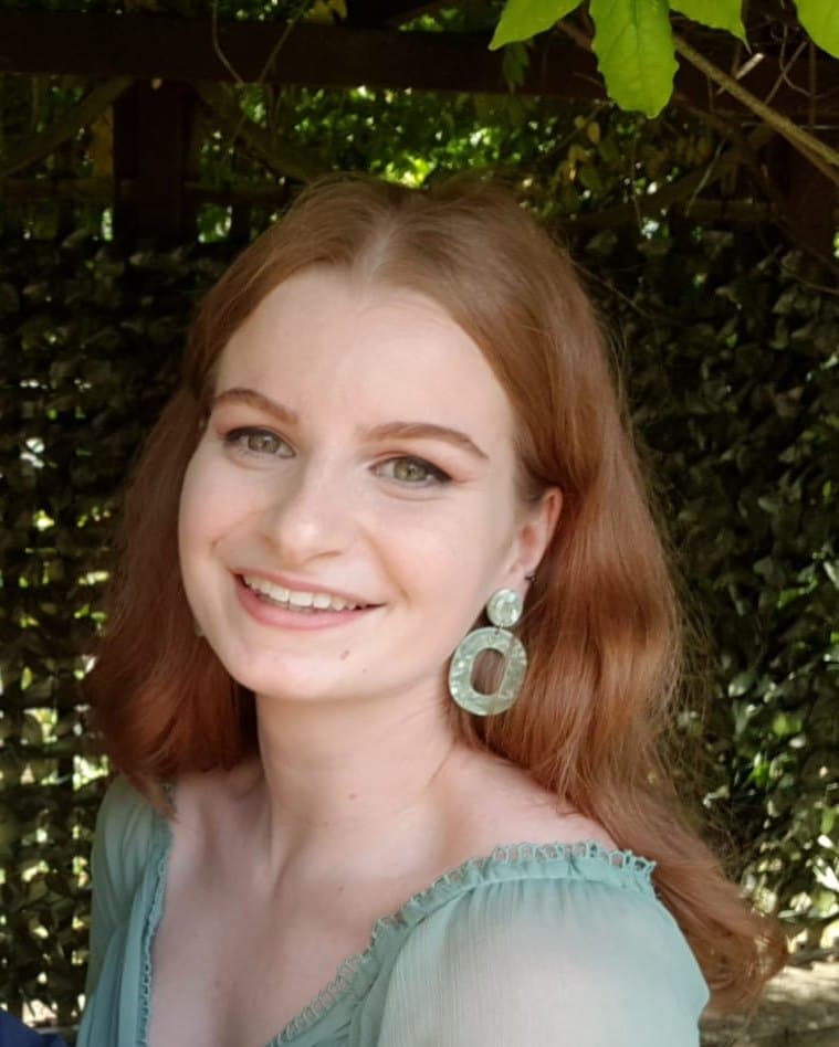 Federica, smiling, with green earrings